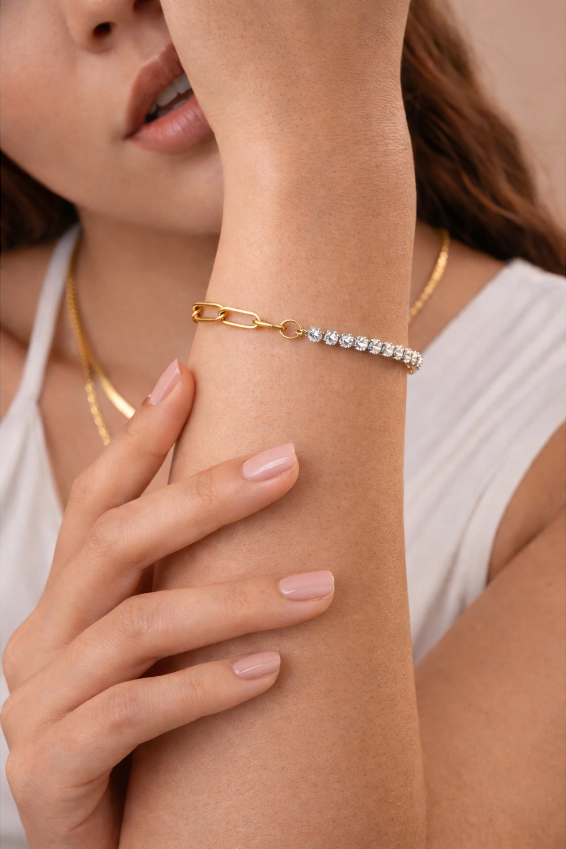 Close-up of a woman's arm wearing two toned cubic zirconia gold bracelet