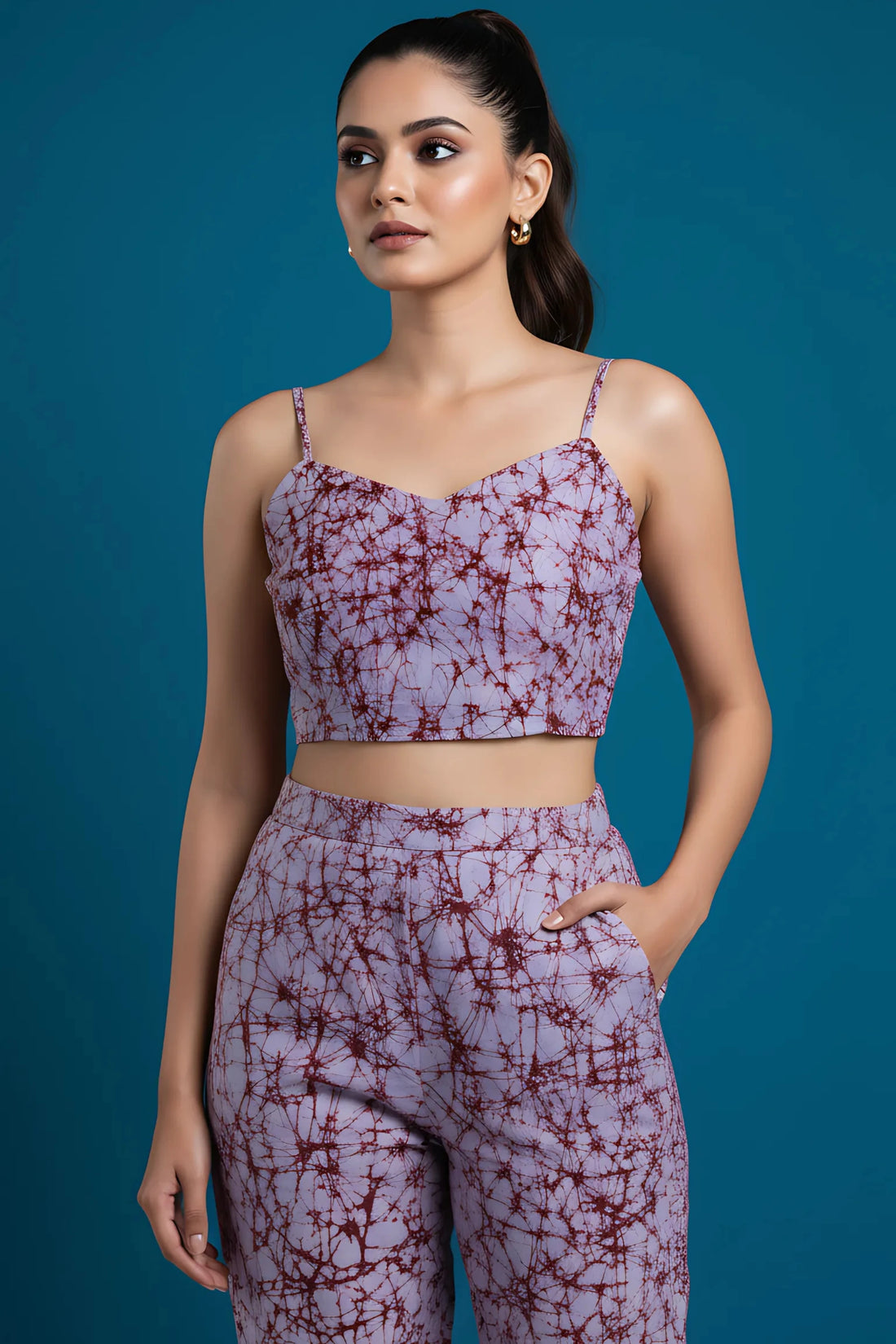 Woman wearing a purple tie-dye outfit against a blue background