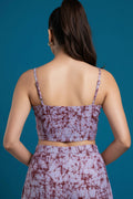 Woman wearing a purple tie-dye dress against a blue background