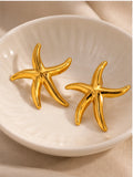 Pair of gold starfish earrings in cream ceramic dish