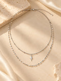 Silver layered necklace with tiny star charm and delicate chains flat lay | SKREAM