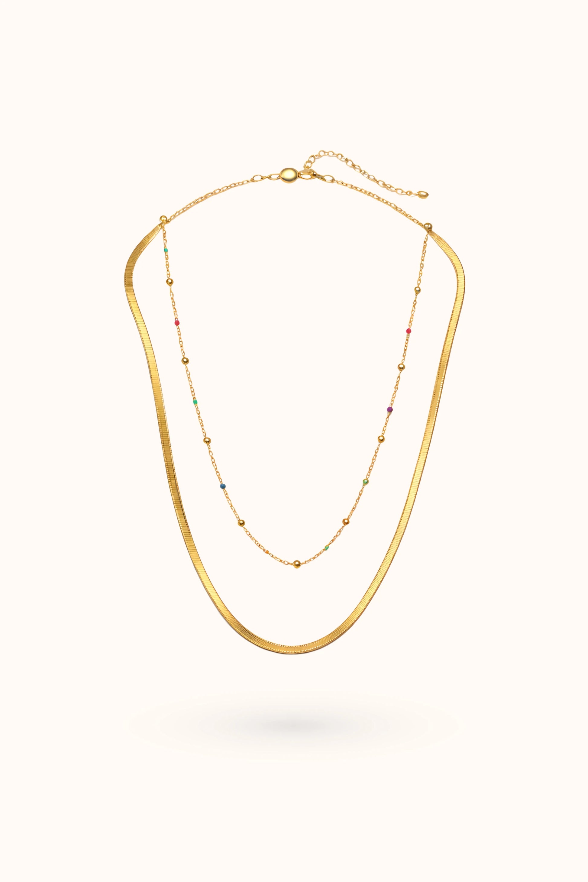 Gold necklace with small beads on a white background